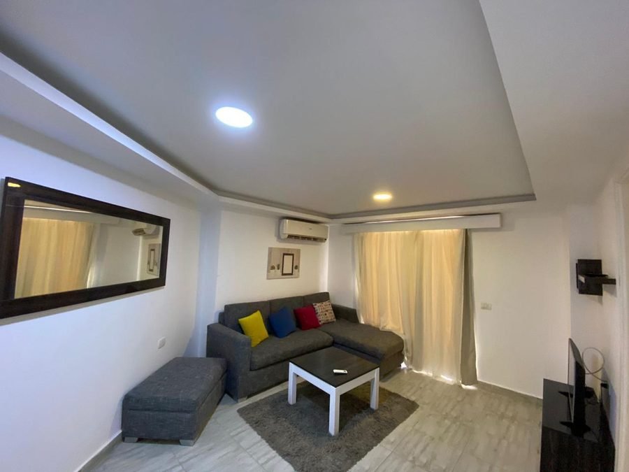 Penthouse v Aqua Palms — obývací část s pohovkou a televizí