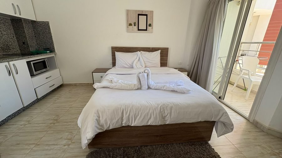 Studio v Aqua Palms — postel u balkonových dveří