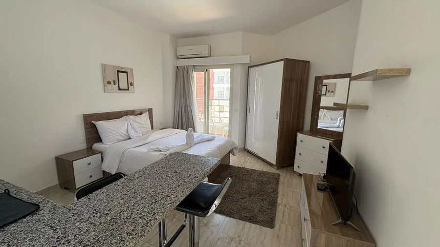 Studio Palms ad Aqua Palms — monolocale arredato con letto, armadio e televisore